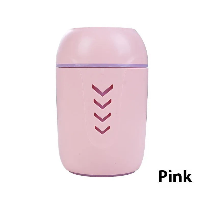 Round blue portable air purifier and aromatherapy diffuser unit with USB cable on a wooden desk.