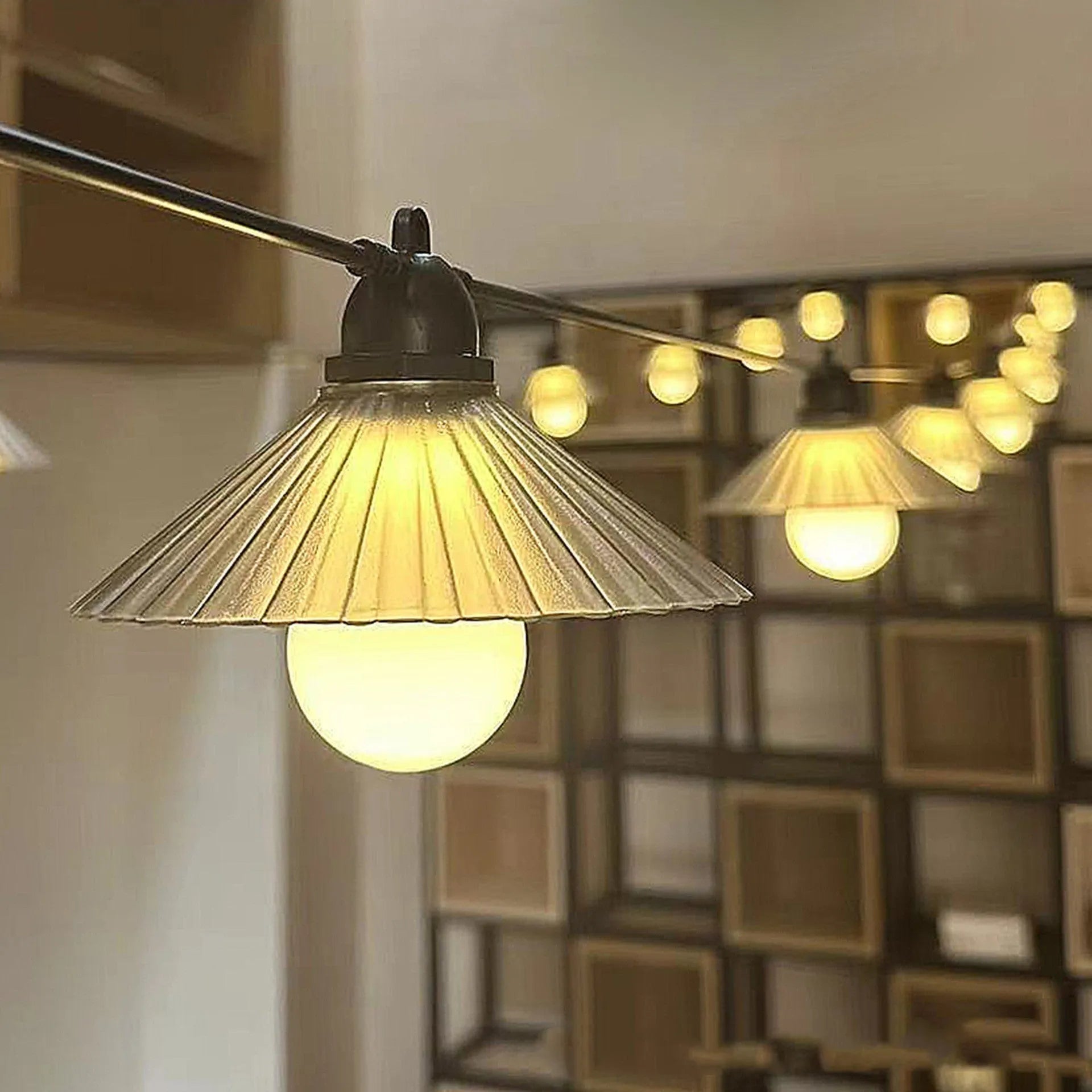 Outdoor LED string lights with white flower-shaped bulbs hanging in a garden.