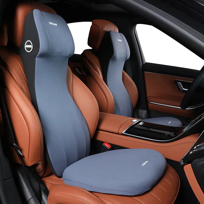 Black memory foam automotive lumbar support cushion with integrated headrest on a car seat.