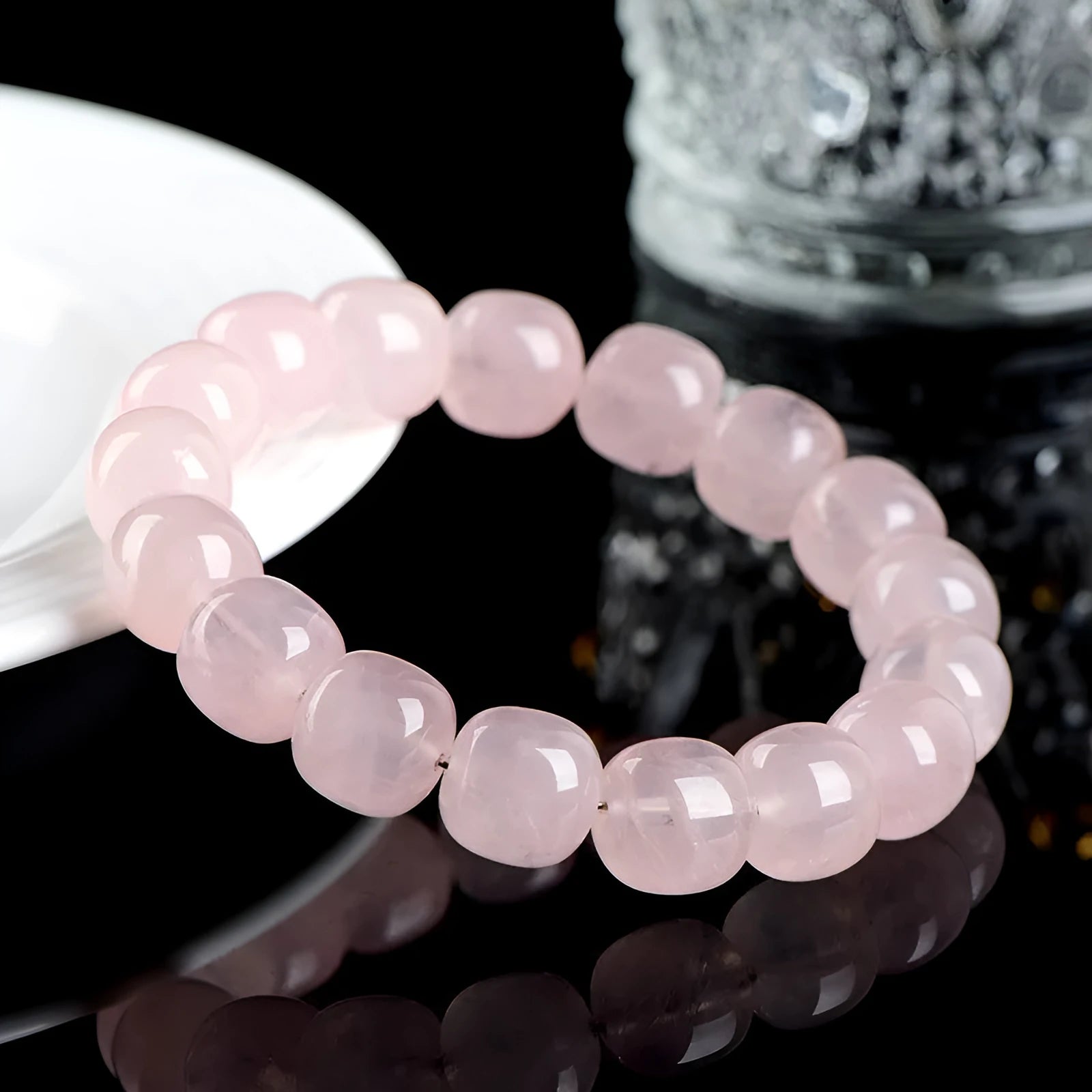 Pink barrel crystal bead bracelet with geometric design on wrist.