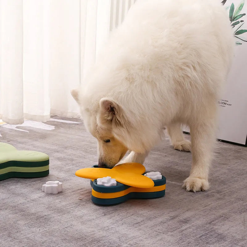Green and yellow dog puzzle toy with rotatable treat dispenser and nine bone-shaped compartment covers