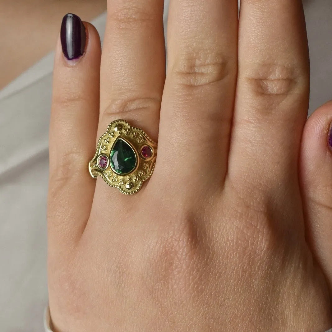 Gold-plated women's alloy ring with geometric shape and lvzuan colour on a white background.