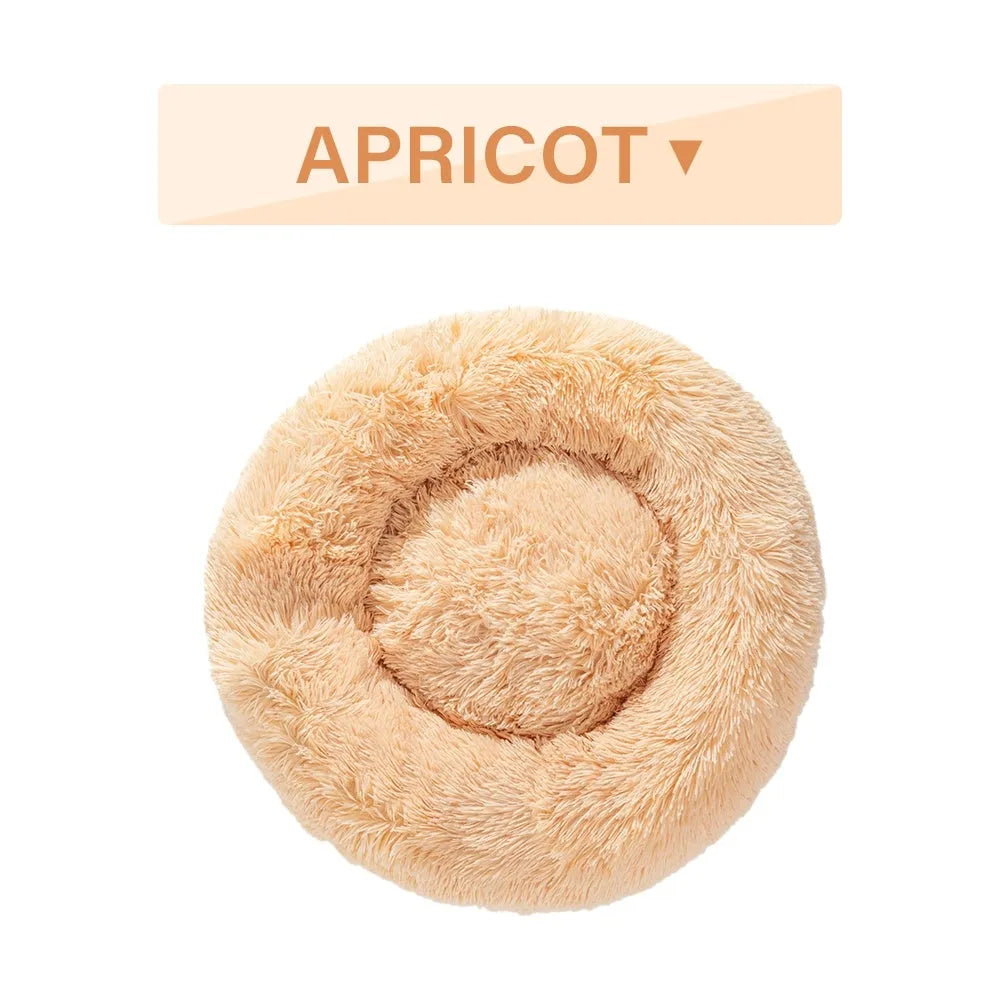 Fluffy grey donut-shaped dog bed with raised plush edge on a wooden floor.