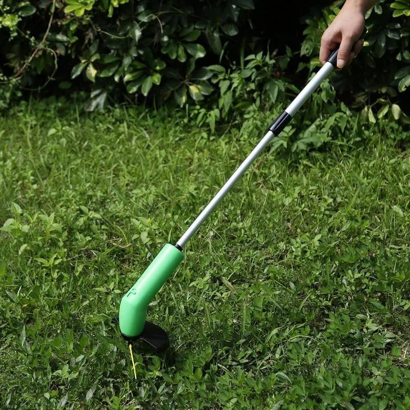 Cordless zip tie lawn trimmer with extension pole and protective debris shield on grass.