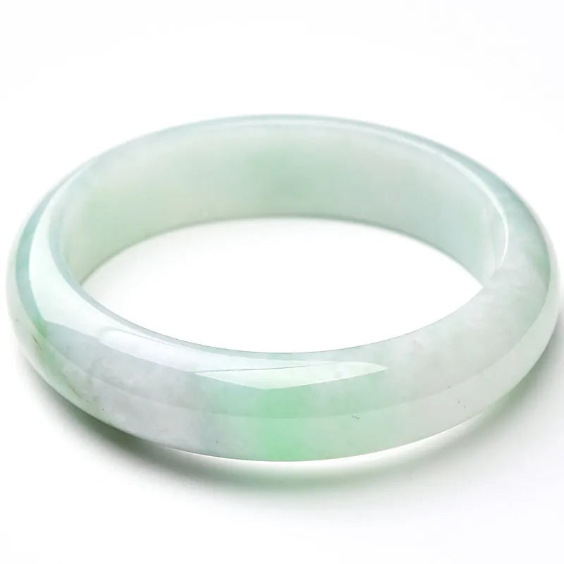 Natural light green jade bracelet with a metal clasp, shown on a wrist.