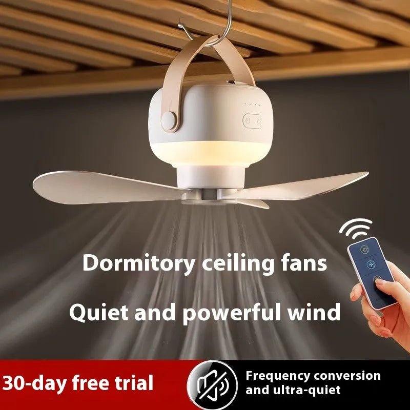 Small white rechargeable ceiling fan with fan blades and night light, hanging from a metal wire bracket for camping
