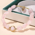 Crystal agate bracelet with natural gemstone beads and zodiac charm on a wrist.