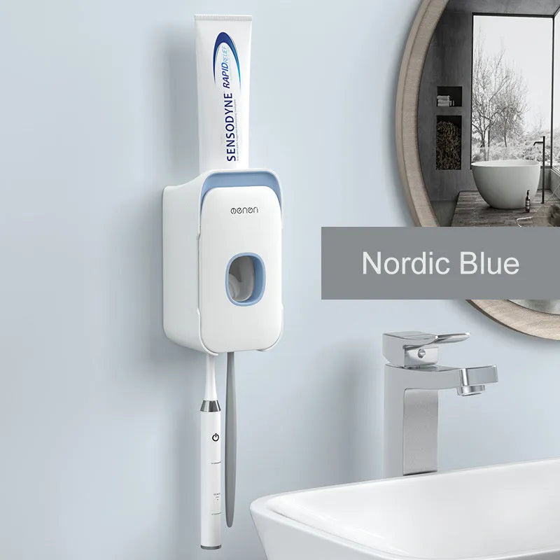 Wall-mounted automatic toothpaste dispenser in blue, grey, or pink colours with a visible dispensing lever.