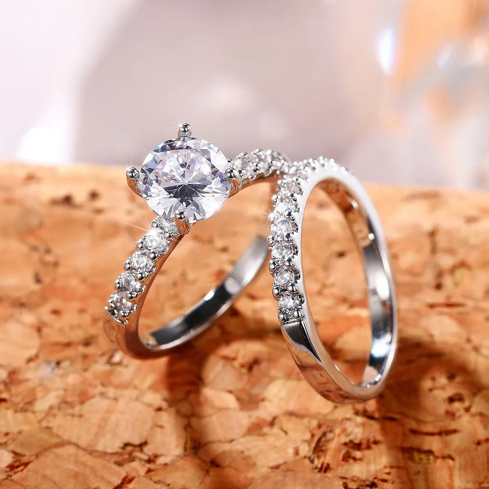 Two matching copper couple rings with a white gold finish and a small zircon stone inlay on a white background