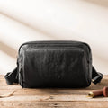Black cowhide leather shoulder bag with zipper closure and interior organisation pockets