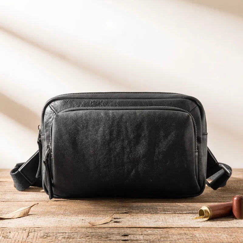 Black cowhide leather shoulder bag with zipper closure and interior organisation pockets