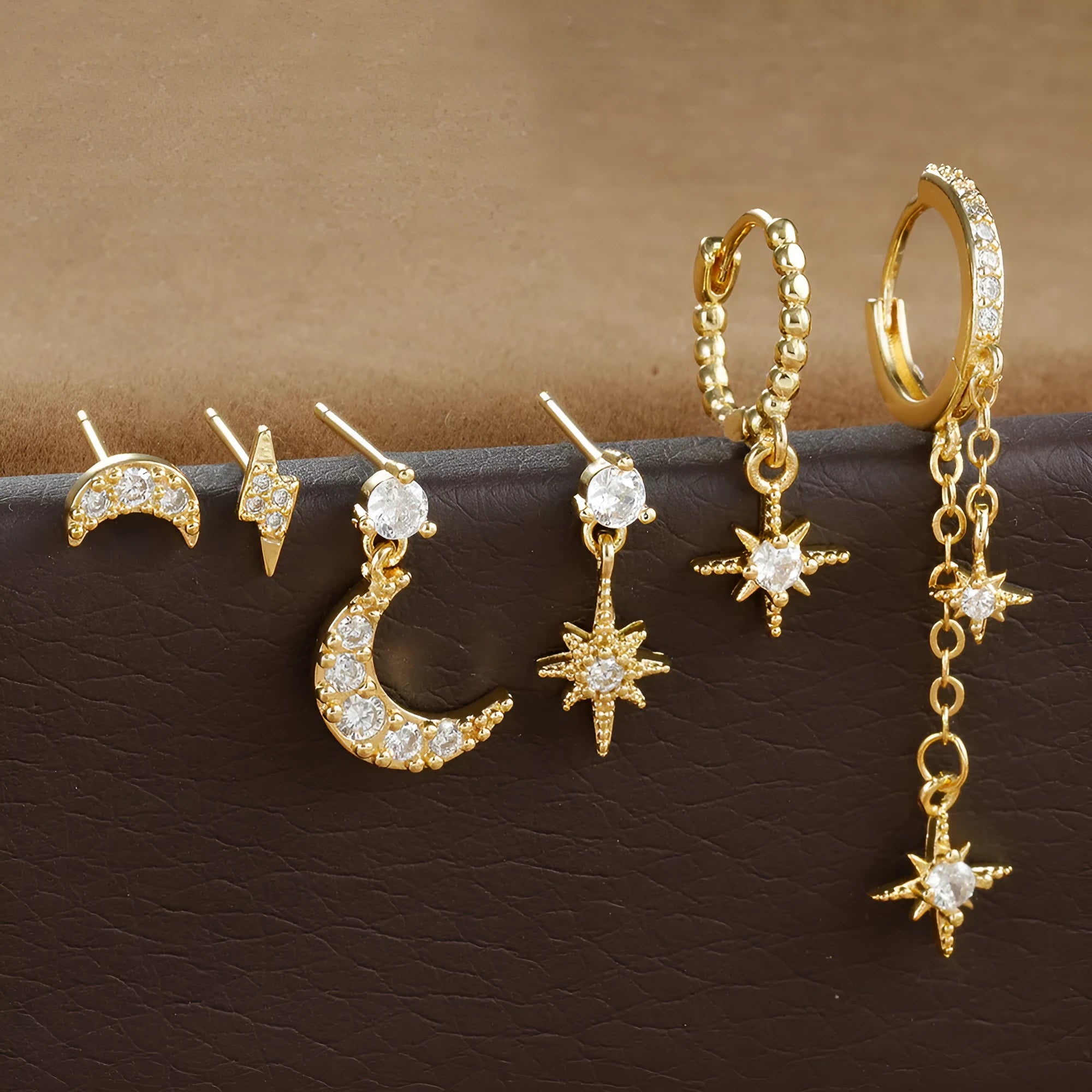 Set of six gold-colour chain tassel earrings with zircon studs, shown arranged together.