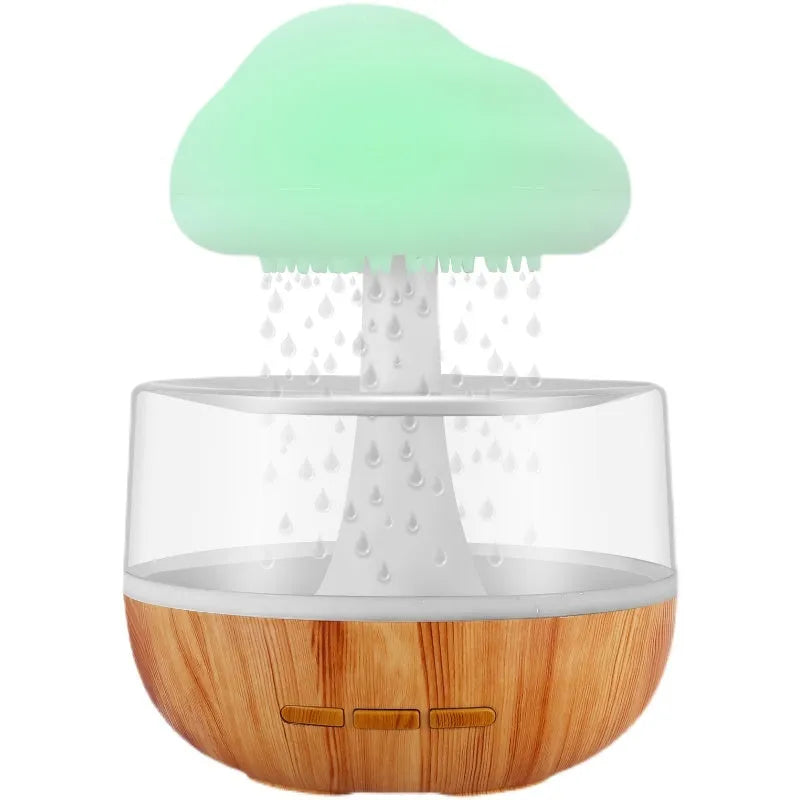 White cloud-shaped portable humidifier with coloured night light on a wooden table.