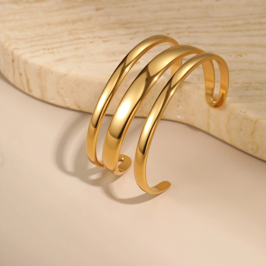A geometric line design bracelet for women on wrist, shown in stainless steel with a simple opening clasp.