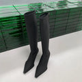 Women's black pointed toe stiletto boots with a back zipper, shown from the side.