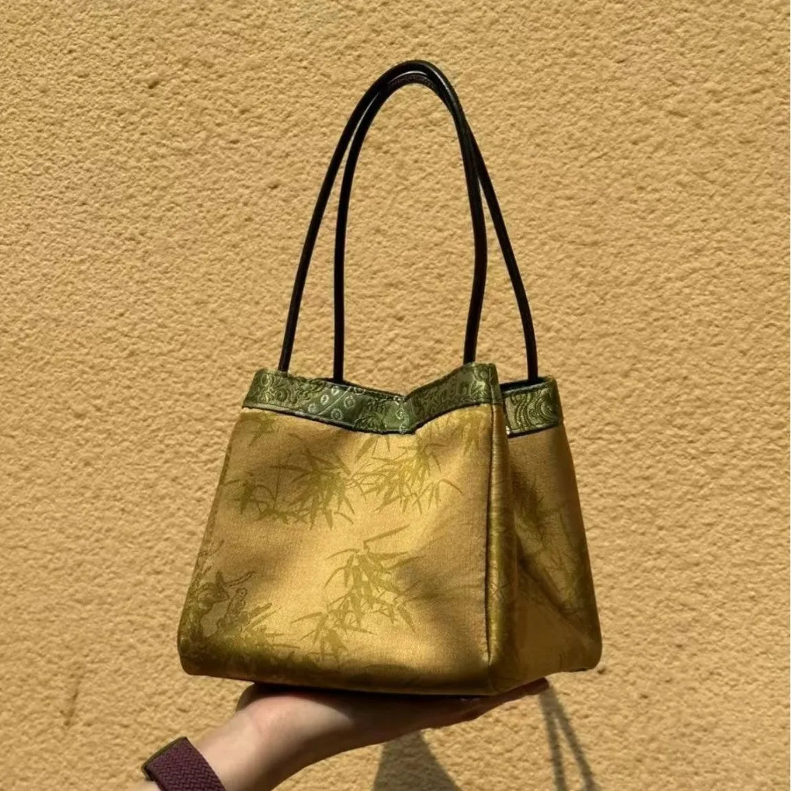 Gold PU leather small square handbag with tassels and sewing line detail on white background