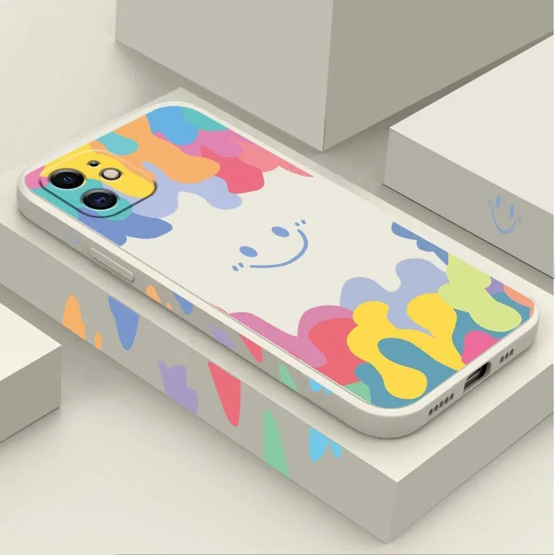 White silicone phone case with a rainbow smiley face design and a black lanyard attached.