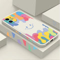 White silicone phone case with a rainbow smiley face design and a black lanyard attached.