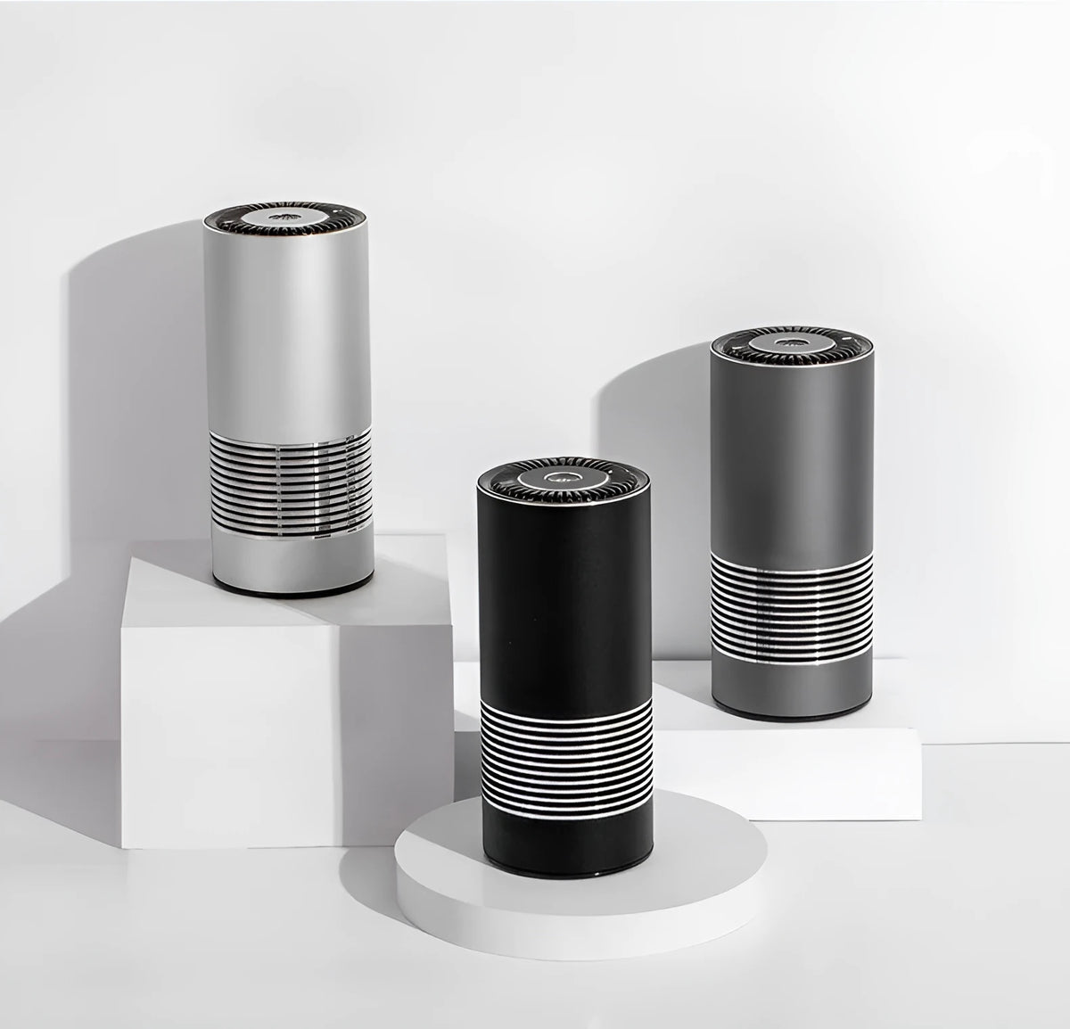 Compact aluminium alloy car air purifier in black, silver, or metallic grey for dashboard use.