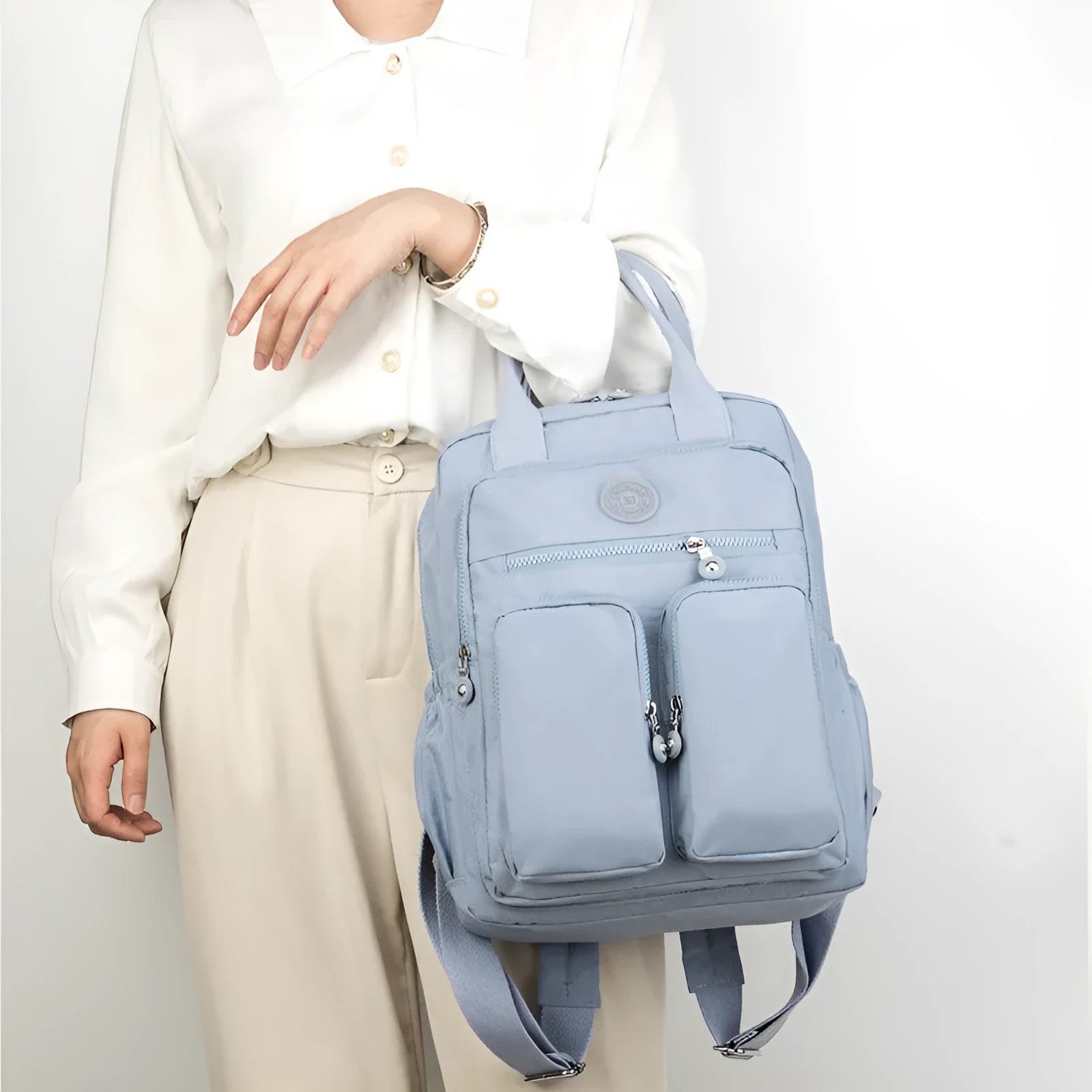 Large soft nylon waterproof backpack in grey, open to show internal laptop, camera, and phone compartments.