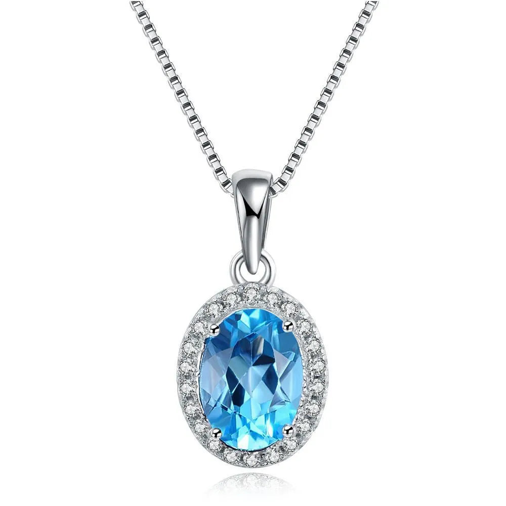 Women's sterling silver jewellery set with blue topaz stones, showing geometric earrings, necklace, ring, and pendant.