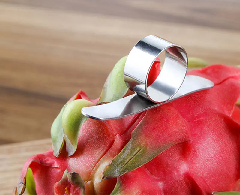 Stainless steel ring orange peeler on a countertop with citrus fruits nearby, showing compact silver tool