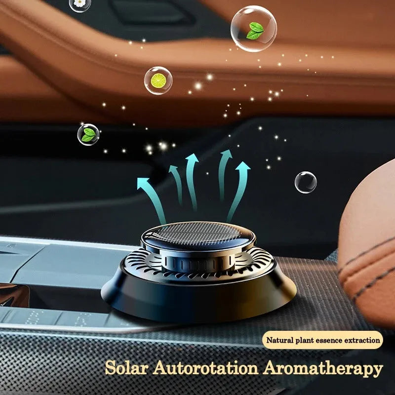 Black solar-powered car air freshener with rotating double rings on car dashboard