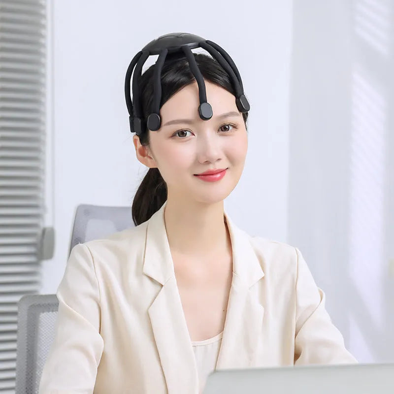 Black or white USB head massager with multiple claws for scalp vibration.