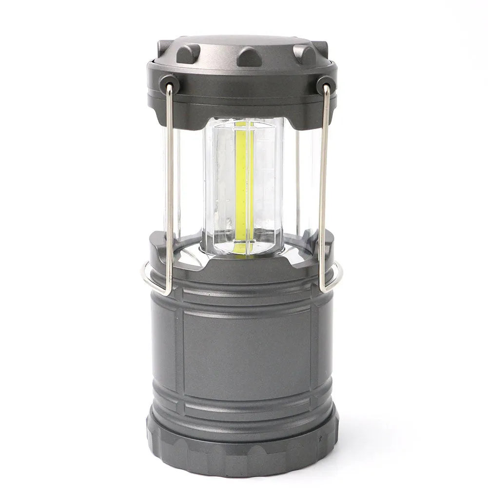 Gold multifunctional COB camping lantern with solar panel, telescopic design, and hook on a wooden table
