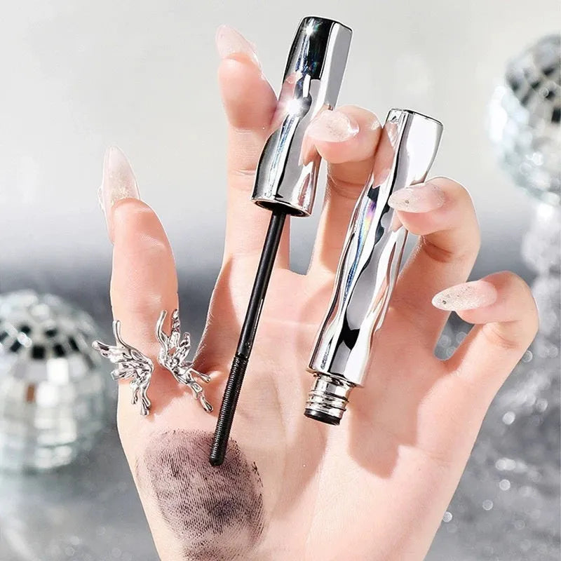 Waterproof black and brown mascara in a steel tube, shown with an optional eyelash curler.