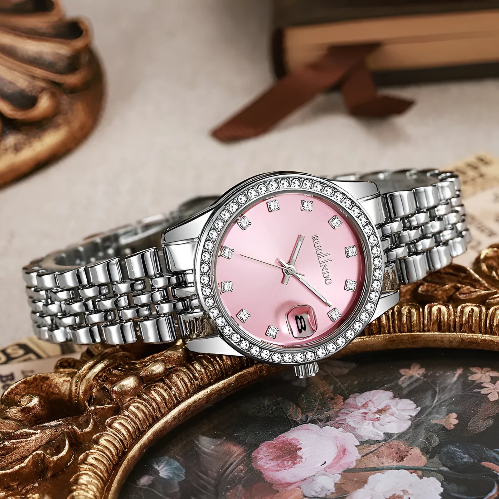 Women's silver alloy quartz watch with circular dial and stainless steel folding buckle on a wrist.