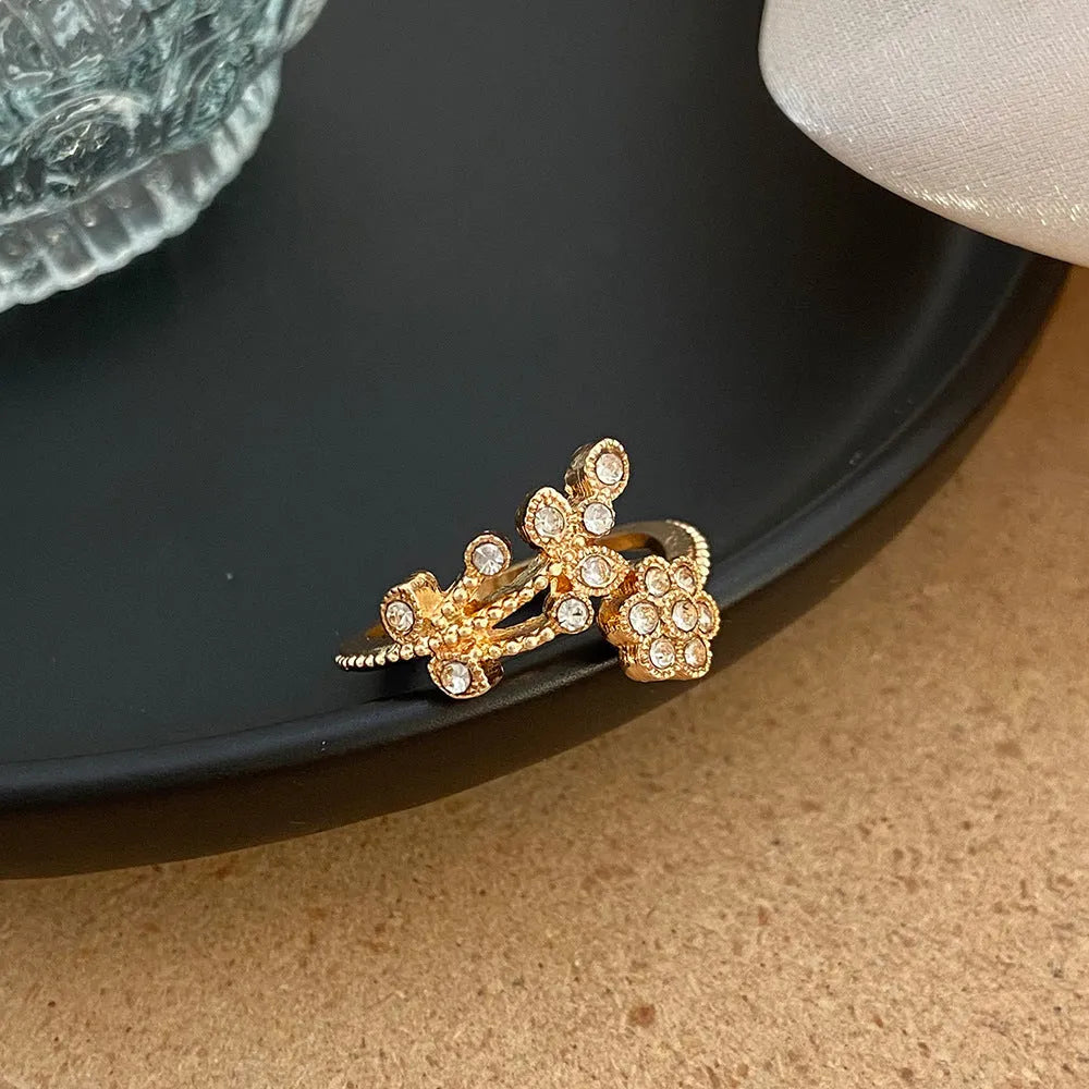 Women's copper open ring with a diamond-faceted flower and leaf design in gold and white colour options.
