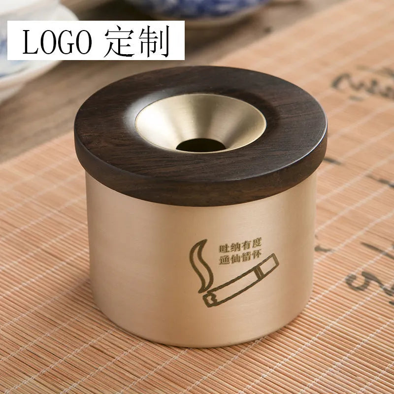 Retro-style solid copper ashtray with a wooden lid featuring a centre hole, shown in brass and black wood or brass and red wood.