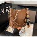 Women's retro PU messenger bag in brown with compact bucket shape, pendant, and double shoulder strap connector