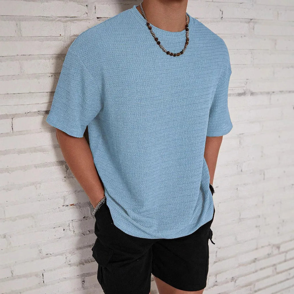 Man wearing a light blue loose fit slim style round neck short sleeve T-shirt