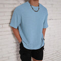 Man wearing a light blue loose fit slim style round neck short sleeve T-shirt