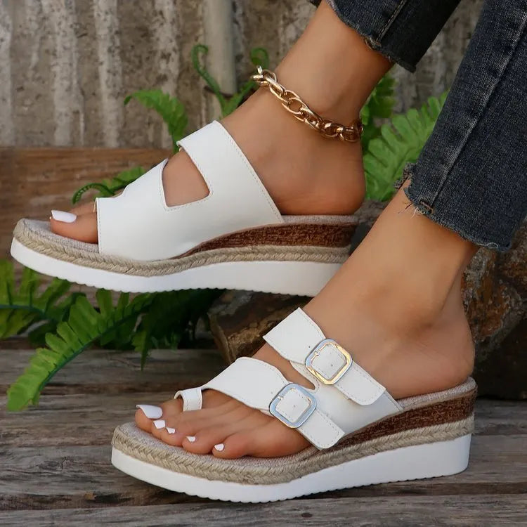 White woven patent leather wedge sandals with a peep toe and finger-fit strap design.