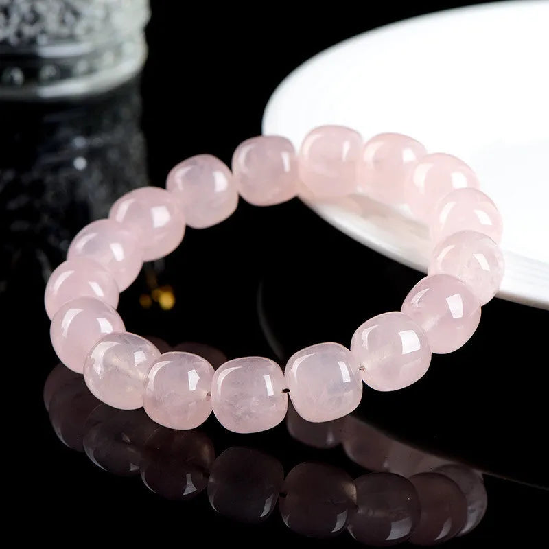Pink barrel crystal bead bracelet with geometric design on wrist.