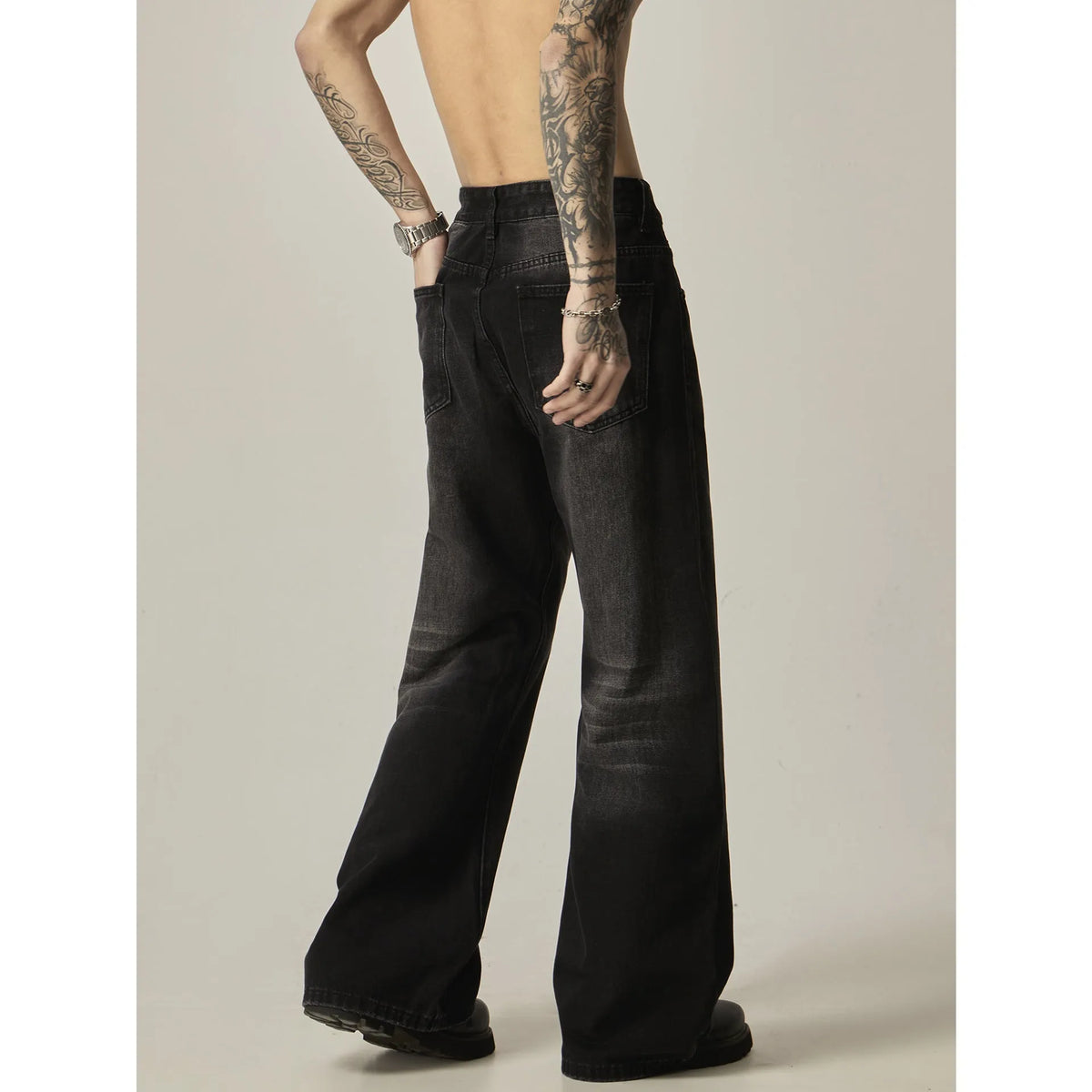 Black loose-fit straight leg denim jeans on a mannequin, showing the zip fly and retro style.