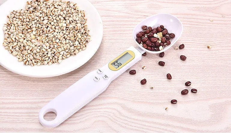 Black electronic measuring spoon scale with digital display on handle and integrated spoon bowl.