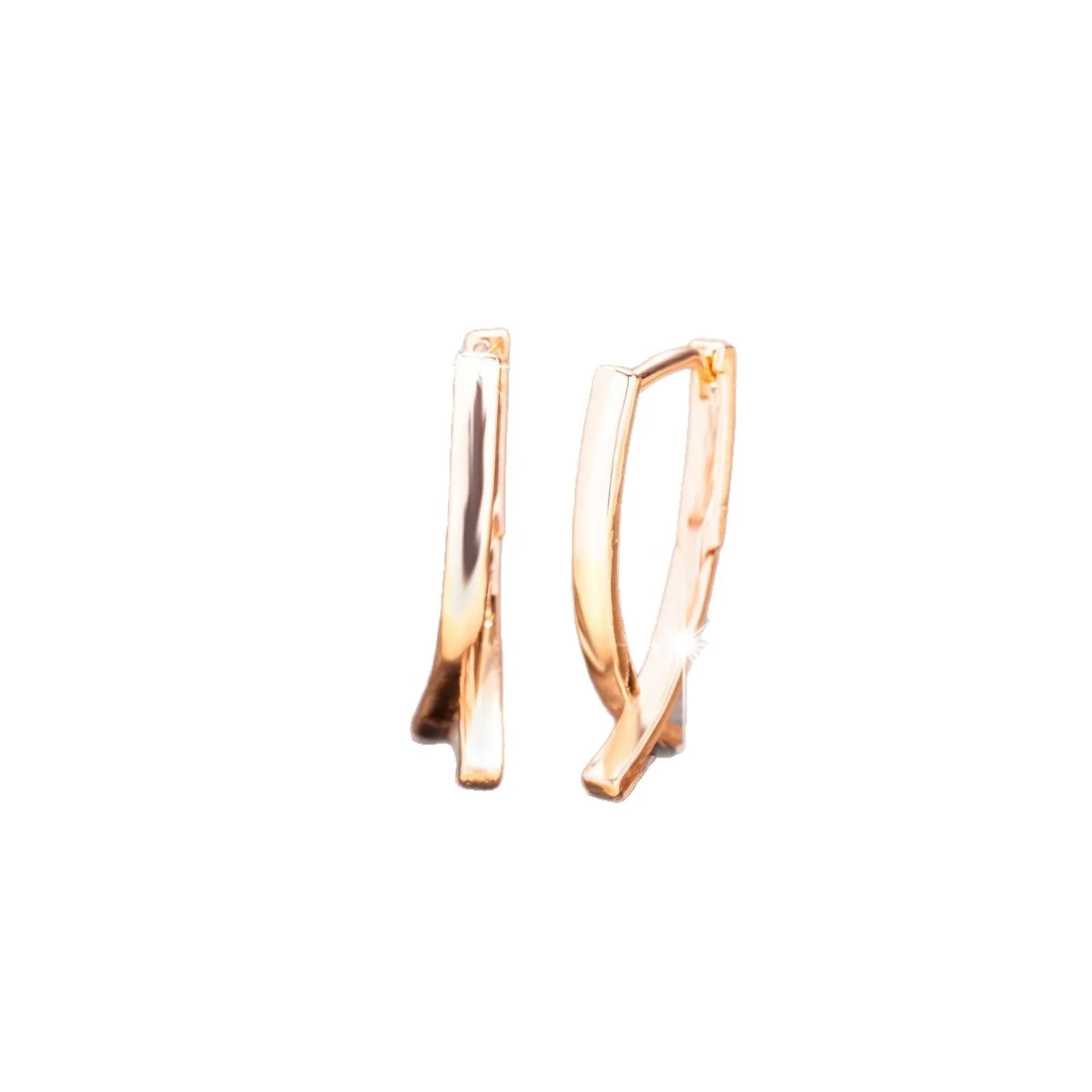 Rose gold cross shaped earrings with copper construction on display card