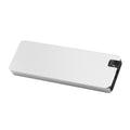 White portable external SSD with metal shell and USB cable next to a laptop.