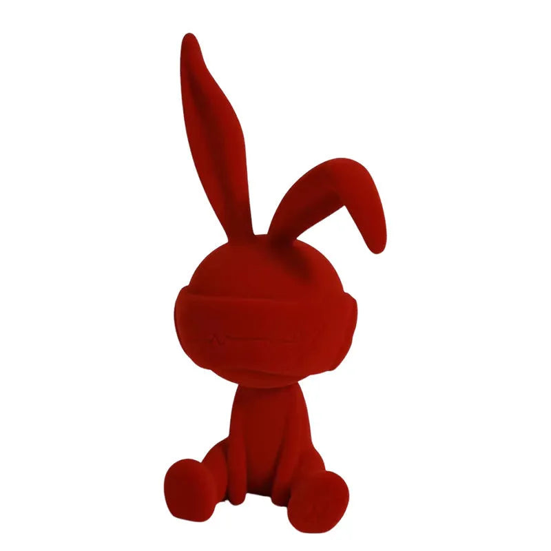 Small resin rabbit ornament wearing a suede blindfold, shown in blue, green, and red colour options.