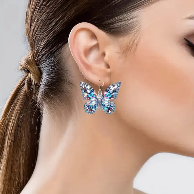 Colourful printed 2D acrylic earrings with butterfly design on a light background