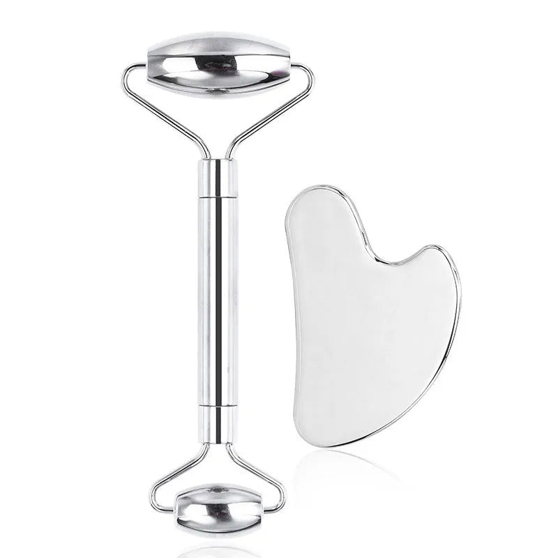 Stainless steel facial massage roller and heart-shaped gua sha plate set on a white background.