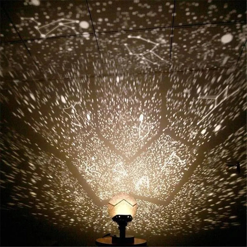 A white plastic LED star projector night light with remote control on a table.
