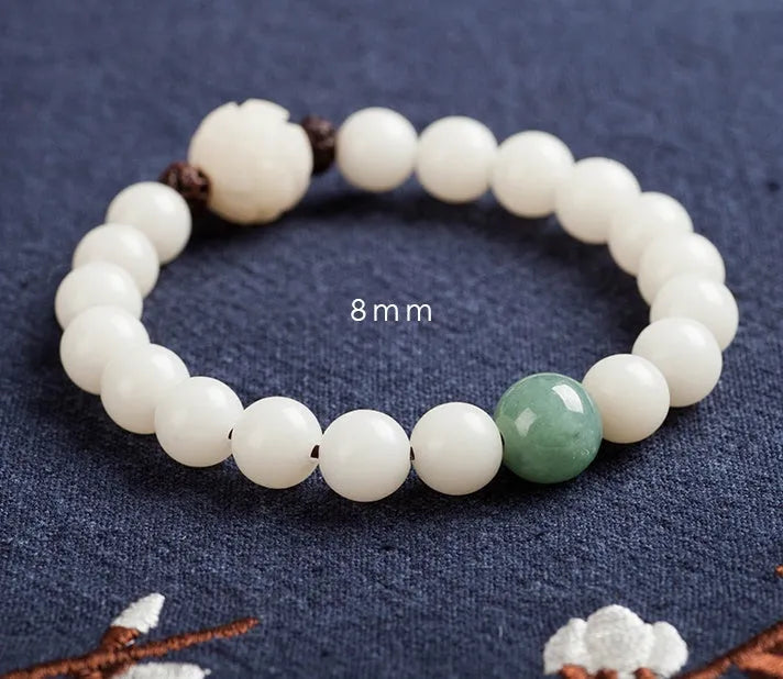 Natural white jade Bodhi bracelet with transfer beads on a neutral background