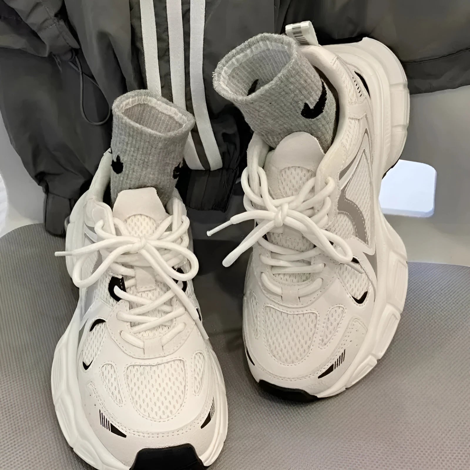 Beige mesh platform sports shoe with a wedge heel and front lace-up design on a white background.