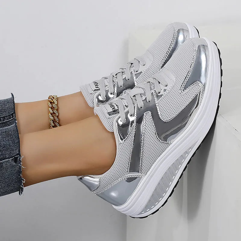 Gold women's mesh platform trainers with cross strap and thick sole on a white background.