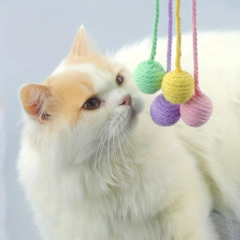 Cat toy ball with rope attached in green, pink, purple, or yellow colours with internal bell